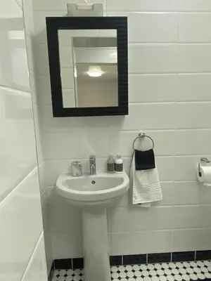 a white bathroom with a sink and a mirror at Sleep on 489 in Pretoria