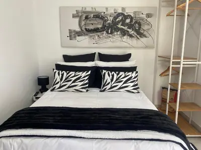 a bedroom with a bed with black and white pillows at Sleep on 489 in Pretoria