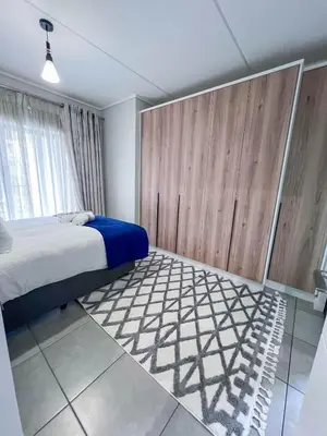 a bedroom with a bed and a large window at Ls apartment in Midrand