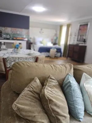 a couch with pillows on it in a living room at Tiny harties in Hartbeespoort
