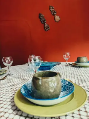 a table with a bowl on a plate and glasses at Tiny harties in Hartbeespoort