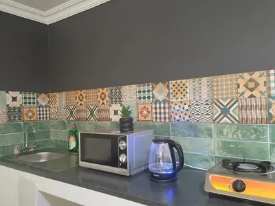 a kitchen counter with a microwave and a sink at Tiny harties in Hartbeespoort