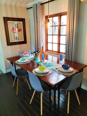 a dining room table with chairs and a wooden table at Mediterranean Palms in Pretoria