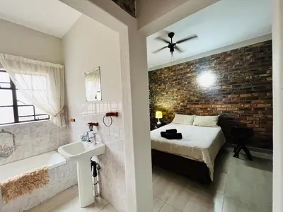 a bathroom with a bed and a sink in a room at Akunandaba - A Bush Retreat in Marloth Park
