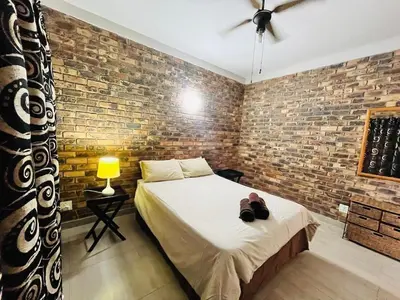 a bedroom with a bed and a brick wall at Akunandaba - A Bush Retreat in Marloth Park