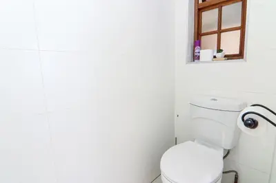 a white bathroom with a toilet and a window at Private room with en-suite bathroom in Pretoria