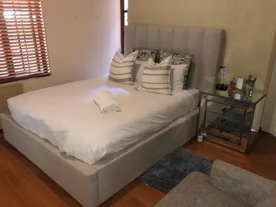 a white bed with pillows on it in a bedroom at Private room with en-suite bathroom in Pretoria