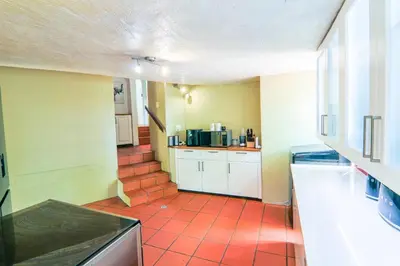 a kitchen with a red tiled floor at Private room with en-suite bathroom in Pretoria