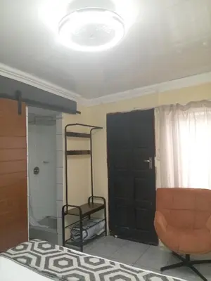a bedroom with a bed and a black door at Comfort Place 4 in Pretoria