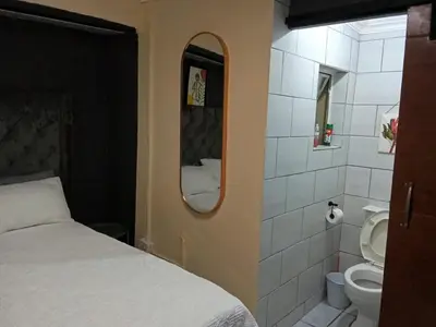 a bedroom with a bed and a toilet and a mirror at Comfort Place 4 in Pretoria