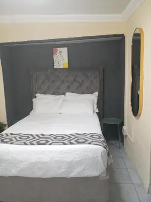 a bed with a black headboard in a bedroom at Comfort Place 4 in Pretoria