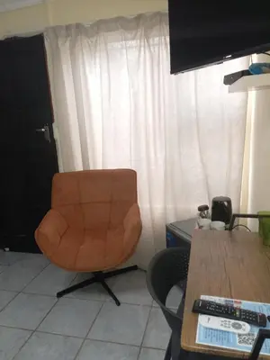 a brown chair sitting in a room with a table at Comfort Place 4 in Pretoria