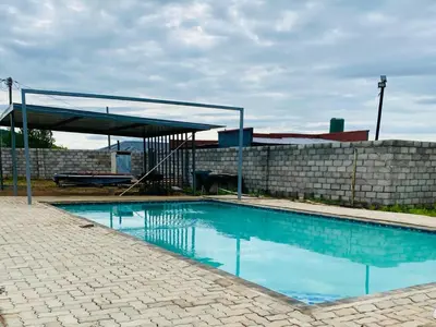 a swimming pool with a canopy next to a brick wall at Morning Star Guest House & Lodge in Burgersfort