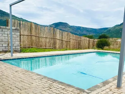 a swimming pool in front of a wooden fence at Morning Star Guest House & Lodge in Burgersfort