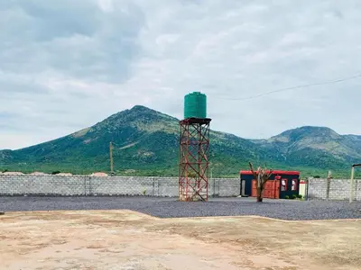 a tower in front of a fence with mountains in the background at Morning Star Guest House & Lodge in Burgersfort