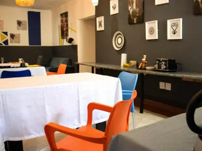 a dining room with two tables and chairs and a counter at Woodpecker's Guest House in Hazyview