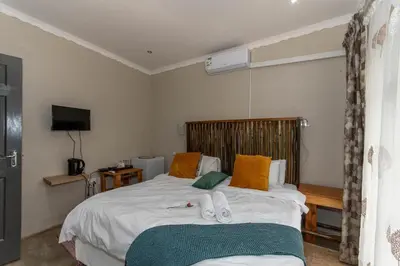 a bedroom with a bed with towels on it at Woodpecker's Guest House in Hazyview