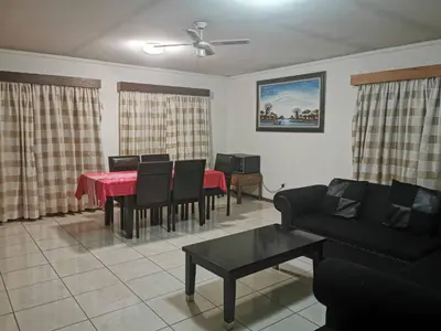 a living room with a red table and chairs at Charming Tshwane BB with Secure Entrance Central AC in Pretoria
