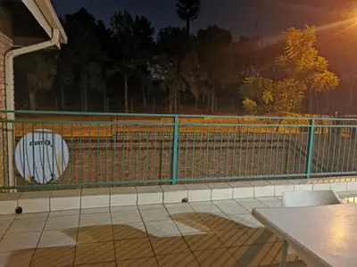 a balcony with a green fence and a table at Charming Tshwane BB with Secure Entrance Central AC in Pretoria