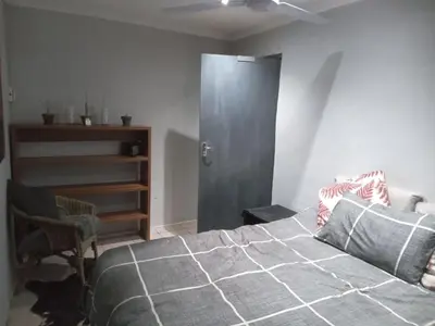 a bedroom with a bed and a gray door at The Chardonay Inn in Centurion
