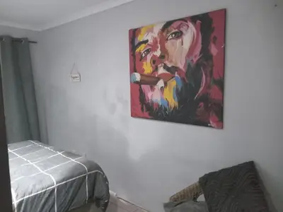 a painting hanging on a wall in a room at The Chardonay Inn in Centurion