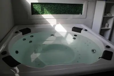 a white bath tub in a bathroom with a window at Aeon Guest House & Spa in Pretoria