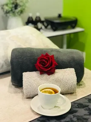 a cup of coffee and a rose on a bed at Aeon Guest House & Spa in Pretoria