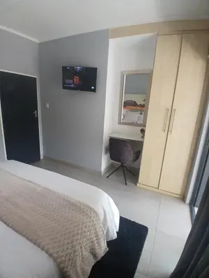 a bedroom with a bed and a desk in it at Aeon Guest House & Spa in Pretoria