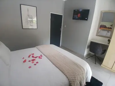 a bedroom with a bed with red flowers on it at Aeon Guest House & Spa in Pretoria