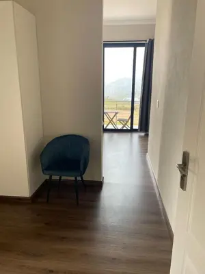 a room with a chair and a door with a view at The Gorge View at Highland Gate in Dullstroom