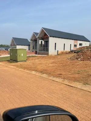 a house being constructed with a building in the background at The Gorge View at Highland Gate in Dullstroom