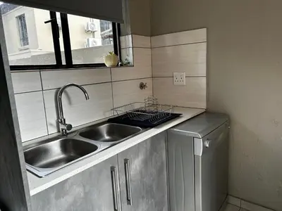 a small kitchen with a sink and a dishwasher at Kingfisher's Song in Nelspruit