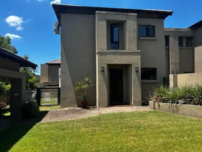 a house with a door and a grass yard at Kingfisher's Song in Nelspruit