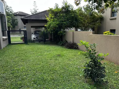 a yard with a fence and a house at Kingfisher's Song in Nelspruit