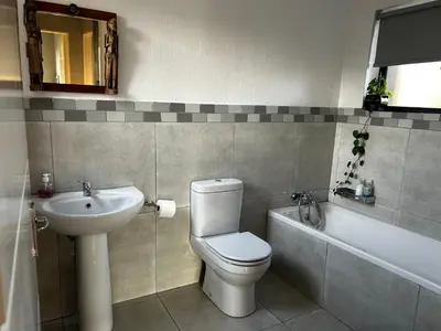 a bathroom with a toilet and a sink and a bath tub at Kingfisher's Song in Nelspruit