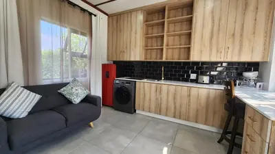 a living room with a couch and a kitchen at Exclusive Stay in Secure Estate in Pretoria