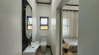 a bathroom with a sink and a mirror and a bed at Exclusive Stay in Secure Estate in Pretoria