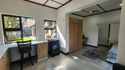 a room with a kitchen and a bedroom with a bed at Exclusive Stay in Secure Estate in Pretoria