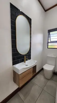 a bathroom with a sink and a mirror and a toilet at Exclusive Stay in Secure Estate in Pretoria