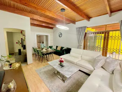 a living room with a white couch and a table at Avenue luxury home in Pretoria