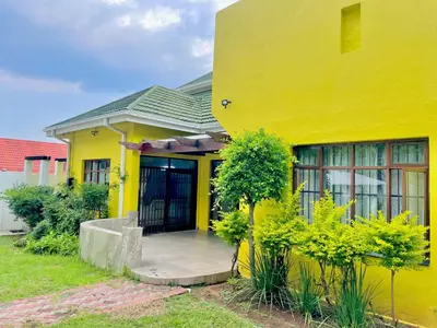 a yellow house with a porch in front of it at Avenue luxury home in Pretoria