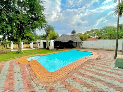 a swimming pool in a yard with a gazebo at Avenue luxury home in Pretoria