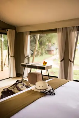 a bedroom with a bed with a tie on it at Elephant Walk Tented Camp in Komatipoort