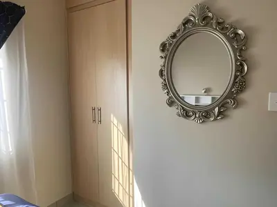 a mirror hanging on a wall next to a door at Capricon Village 3 Bedroom Villa in Centurion