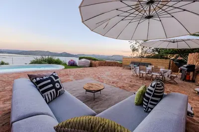 a living room with a couch and an umbrella at Enso Botanico Boutique Villa, Kosmos in Hartbeespoort