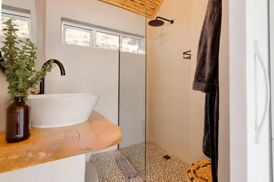 a bathroom with a sink and a glass shower at Enso Botanico Boutique Villa, Kosmos in Hartbeespoort