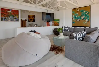 a living room with a large bean bag chair and a couch at Enso Botanico Boutique Wellness Villa, with an outside wood-fire Hot Tub in Kosmos in Hartbeespoort