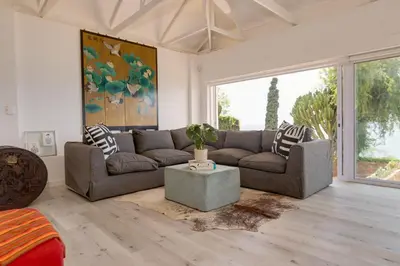 a living room with a couch and a table at Enso Botanico Boutique Wellness Villa, with an outside wood-fire Hot Tub in Kosmos in Hartbeespoort