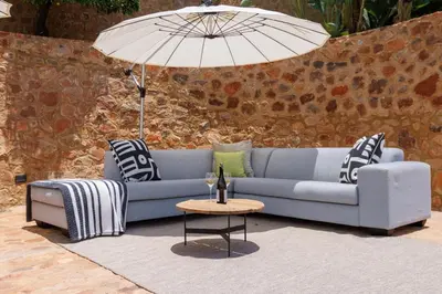 a blue couch and a table with an umbrella at Enso Botanico Boutique Wellness Villa, with an outside wood-fire Hot Tub in Kosmos in Hartbeespoort