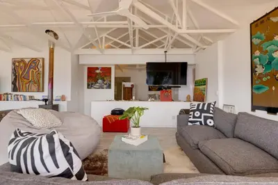 a living room with a couch and a table at Enso Botanico Boutique Wellness Villa, with an outside wood-fire Hot Tub in Kosmos in Hartbeespoort